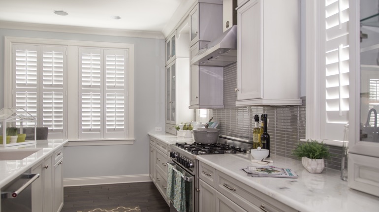 White shutters in Cincinnati kitchen with marble counter.